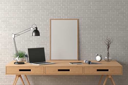 table with laptop computer, lamp, white board, and alarm clock